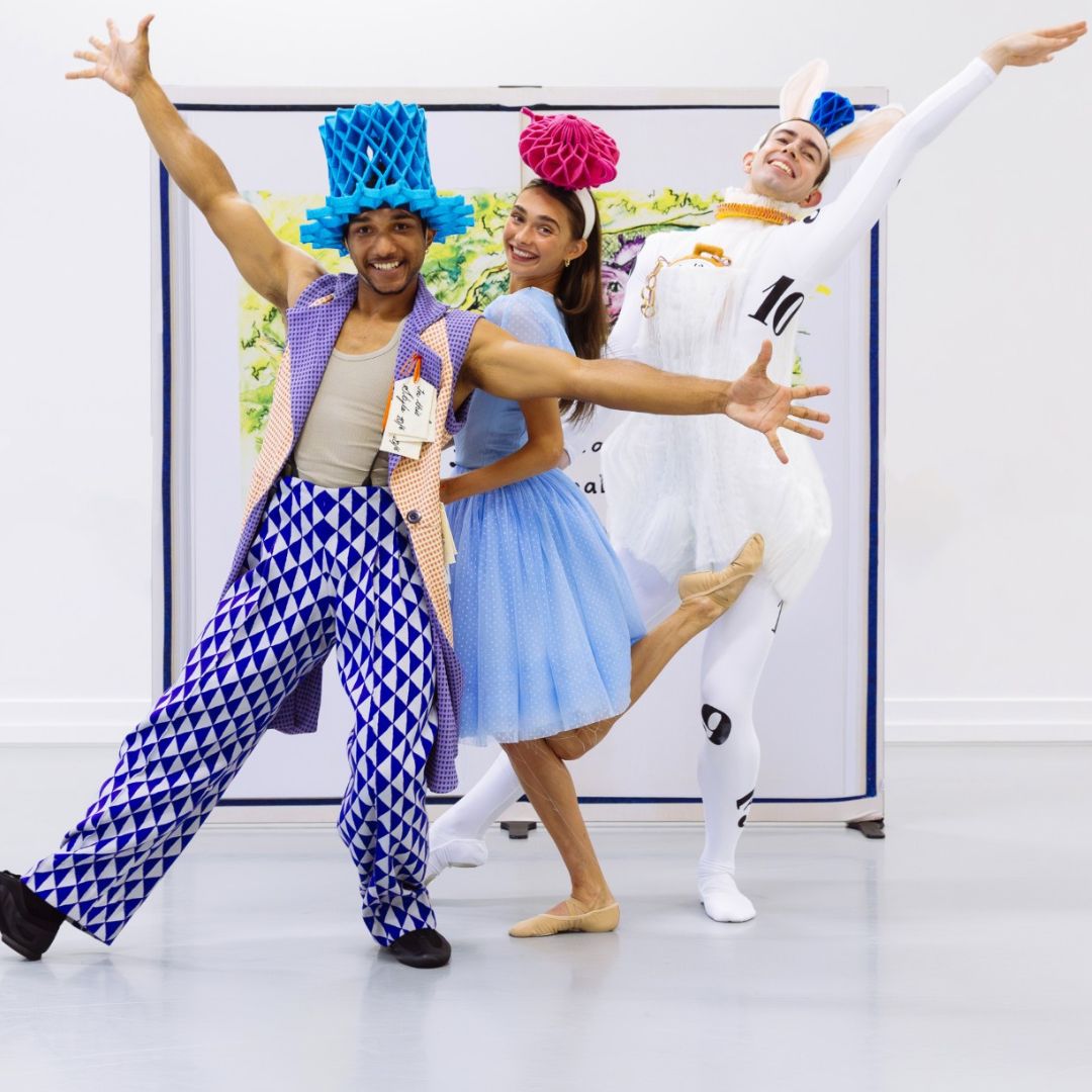 Three ballet dancers costumed as characters from Alice in Wonderland strike a pose
