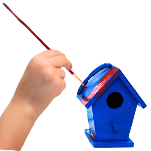 A child's hand painting a red stripe on a blue birdhouse with a paintbrush.