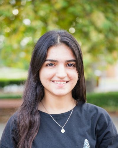 Photo of Majida smiling in front of the Library