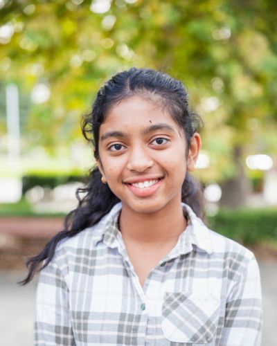 Photo of Richa smiling in front of the Library.